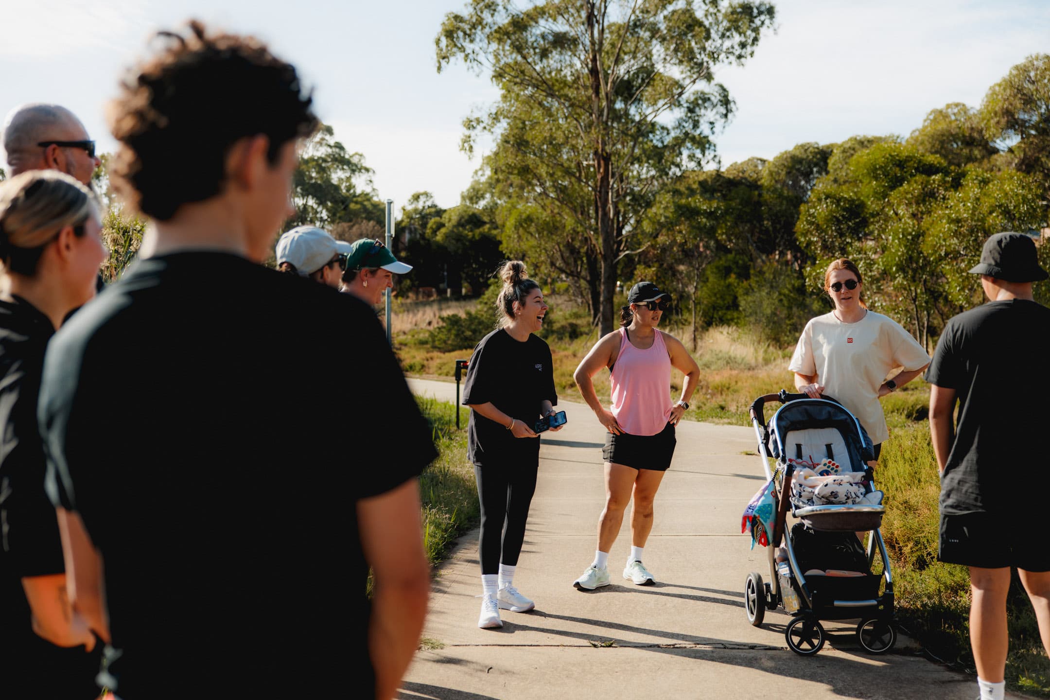 Members chatting on the path with a stroller — all paces welcome